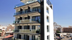 Un edificio a più piani con balconi, ampie finestre e una vista aperta sulla città circostante.