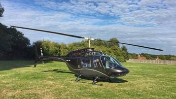 Een helikopter met het registratienummer G-OETI geparkeerd op een grasveld.