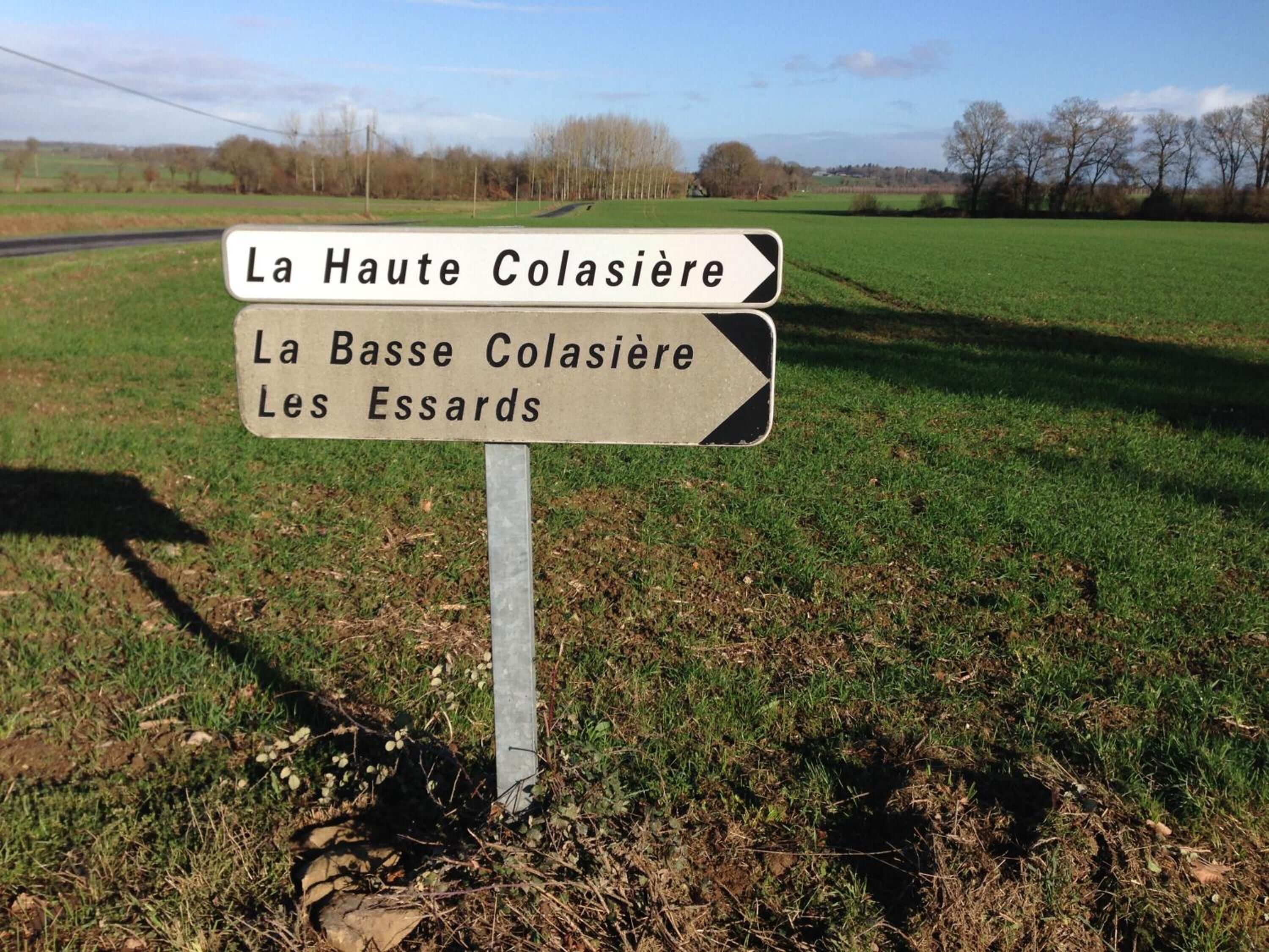 Un panneau de signalisation indiquant la direction à suivre, avec des flèches pointant vers La Haute Colasière et La Basse Colasière, ainsi que vers Les Essards.
