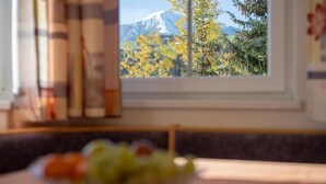A kitchen with a window view of a mountain and trees. - Residence Treyer (Terento)