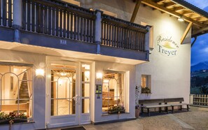 A hotel entrance with a sign reading "Residence Treyer" and a wooden balcony. - Residence Treyer (Terento)