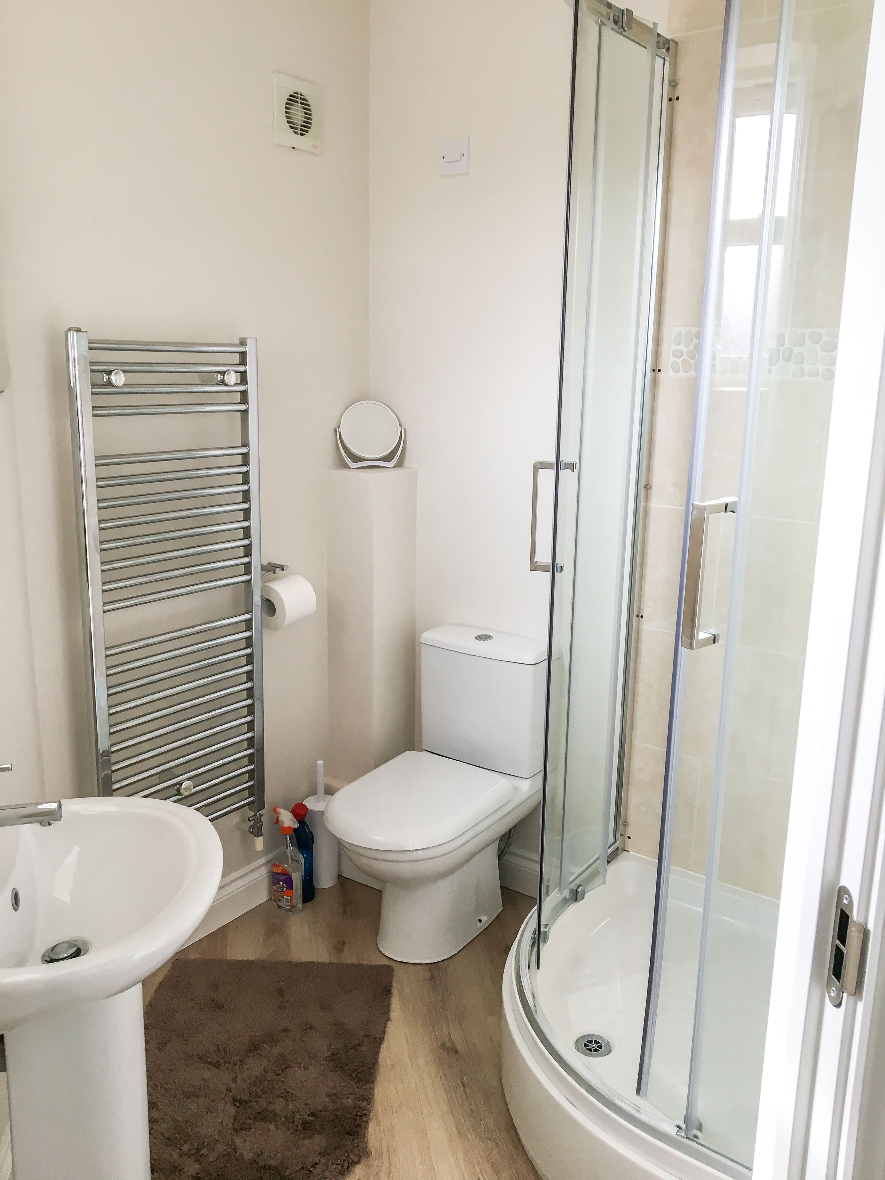 A bathroom with a toilet, sink, and glass-enclosed shower.