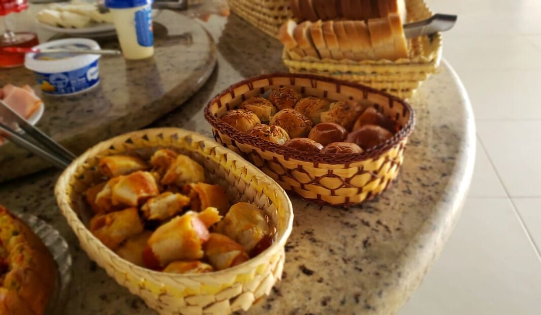 A buffet table with various food items including pastries and bread.