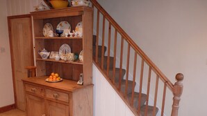 A wooden cabinet with a plate of oranges, a telephone, and various kitchenware. - Grade II listed terraced house in Bath, Somerset (Bath)