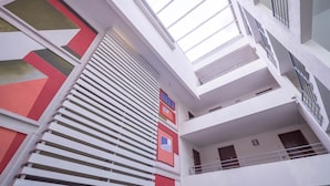 A multi-level building with a modern architectural design, featuring balconies and large windows. - Red Velvet  Apartment (Santiago)
