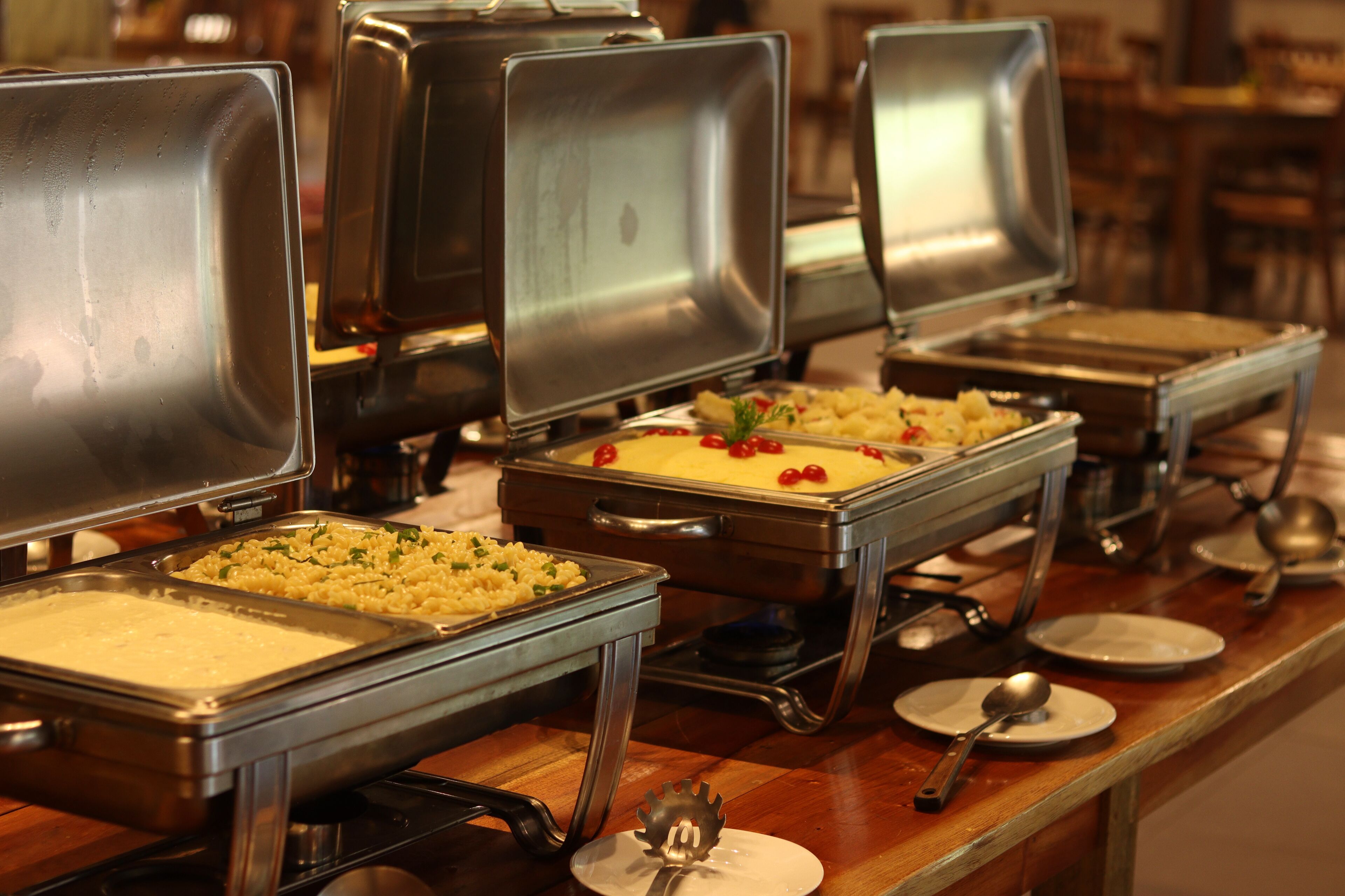 Un bufé con diferentes alimentos en fuentes de metal.