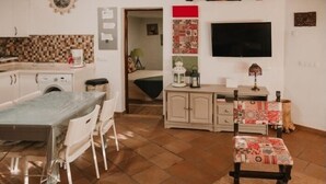 Un espacio habitable compacto con cocina, comedor y una pequeña zona de estar.