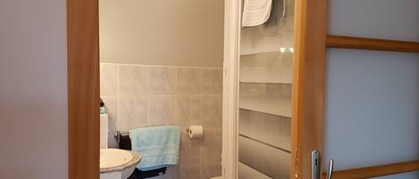 Un baño con inodoro, lavamanos y zona de ducha.