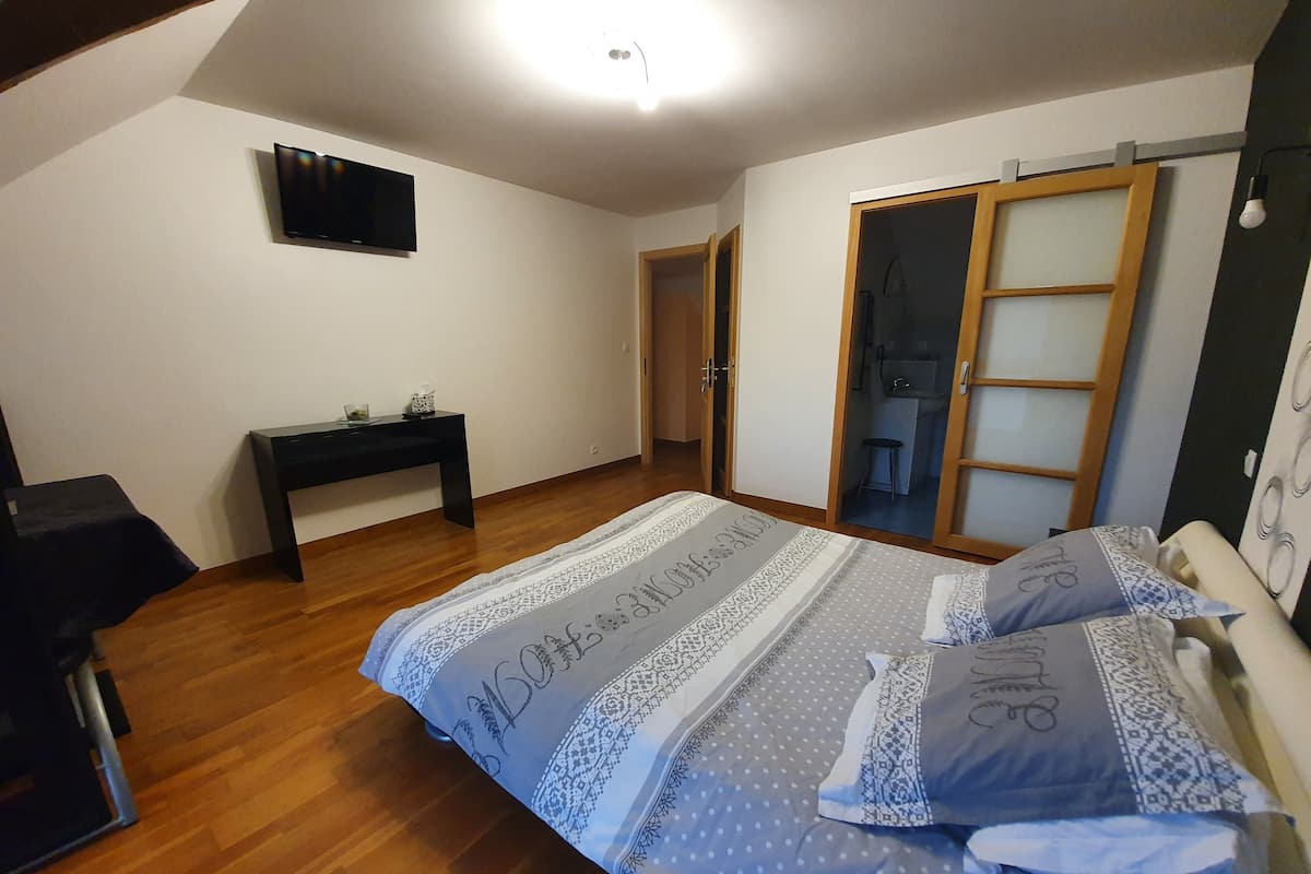 Quarto com cama, escrivaninha e guarda-roupa.