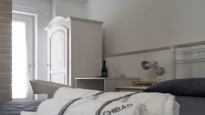 A hotel room with a bed, a nightstand, a lamp, and a wardrobe. - Splendid receptive structure, new construction, anti-seismic. (Ragusa)