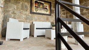 A stone-walled room with wicker furniture and a framed artwork. - Splendid receptive structure, new construction, anti-seismic. (Ragusa)