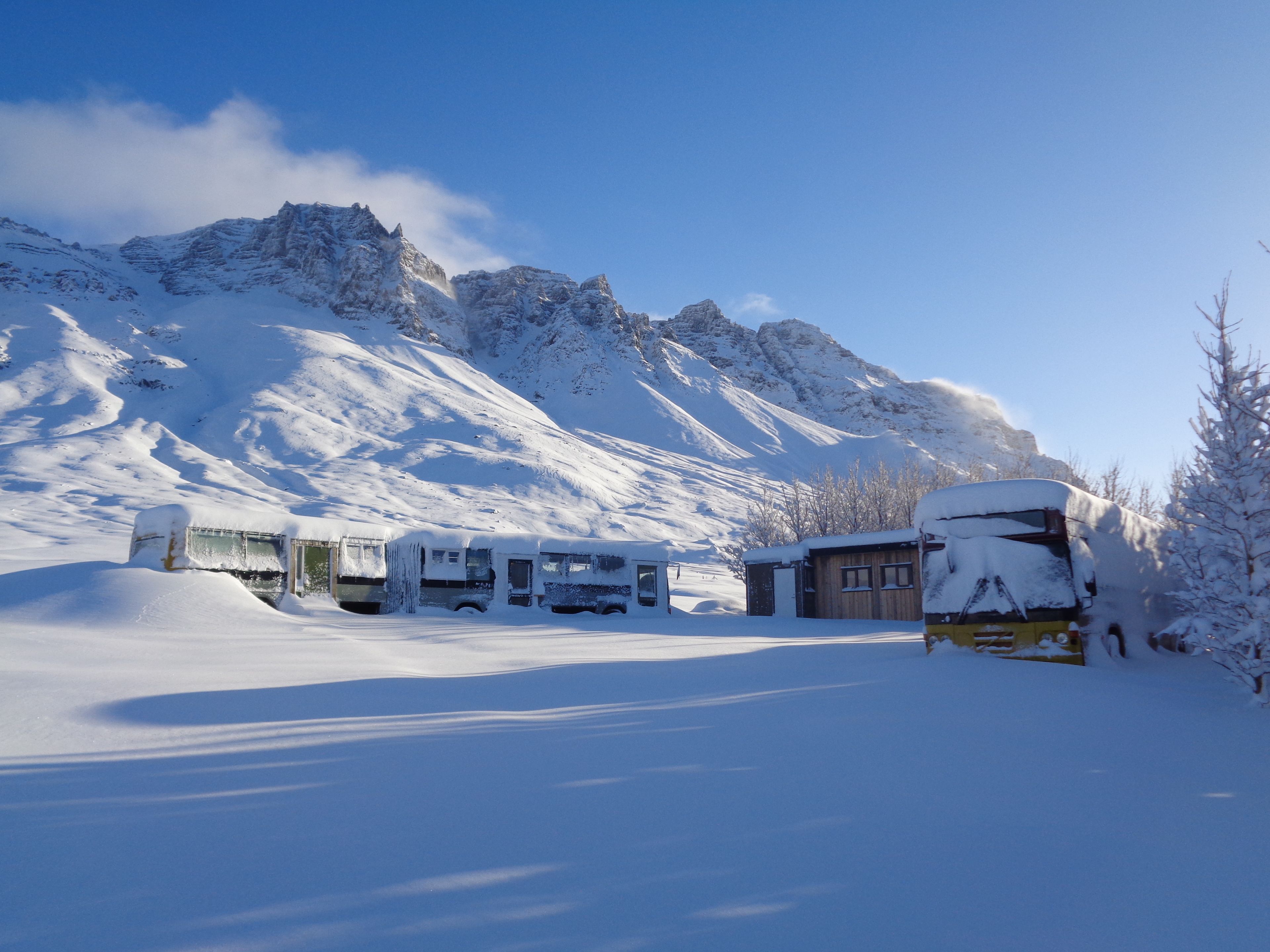 Schneebedeckte Berglandschaft mit Bushaltestelle und einem kleinen Gebäude.