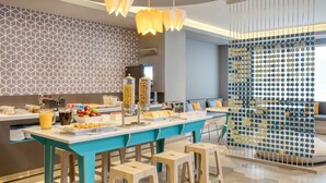 A modern kitchen with a central island, bar stools, and a decorative partition.