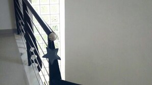 Una escalera con piso de mármol y barandilla de metal.