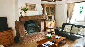 A living room with a fireplace, a sofa, a coffee table, and a television.