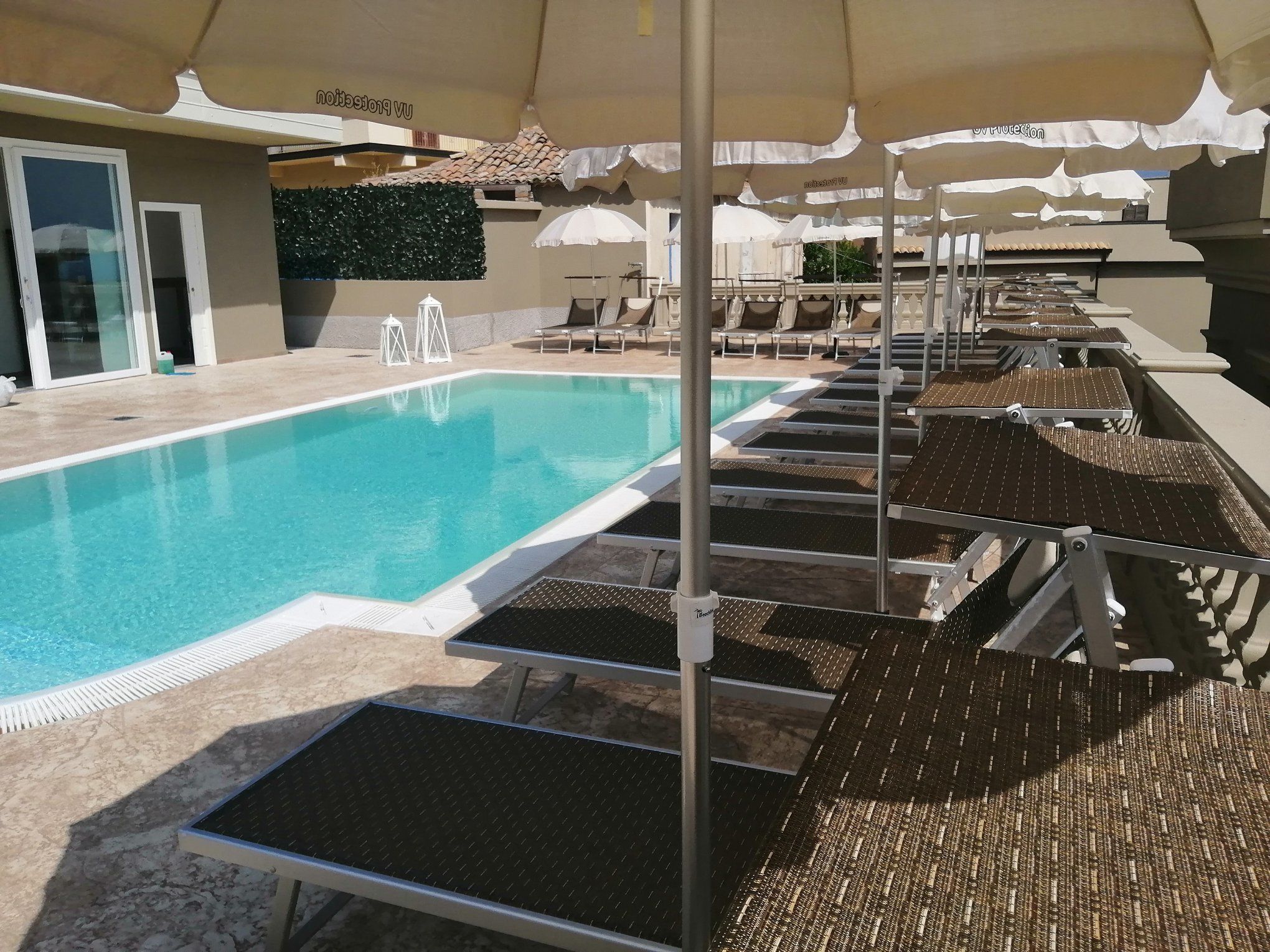 Ein Poolbereich mit Liegestühlen und Sonnenschirmen.