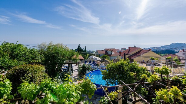 A residential area with a swimming pool, houses with red-tiled roofs, and vineyards. - Apartments Nicol - Two-Bedroom Apartment with Balcony and Sea View (Dubrovnik)