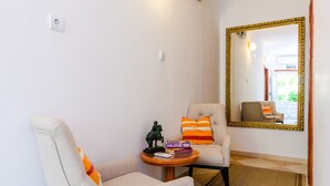 A room with two armchairs, a small table with books and a statue, and a large mirror with a gold frame. - Apartments Nicol - Two-Bedroom Apartment with Balcony and Sea View (Dubrovnik)