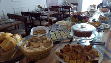 Un bufé con diversos alimentos, como pan, pasteles y un pastel.