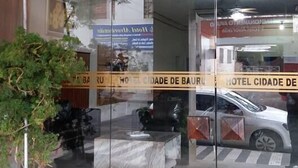 La entrada de un hotel con puertas de vidrio, una planta en maceta y un letrero con el nombre del hotel.