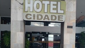 Entrada de hotel con un cartel que dice "HOTEL CIDADE" y el número de la dirección visible "5-56".