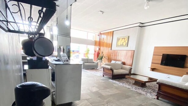 Amplia sala de estar con una cocina moderna, una mesa de centro de madera y un conjunto de asientos cómodo.