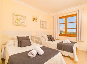 A hotel room with two beds, a window with curtains, and wall decorations. - Apartment CITADINI 39 for 3 to 5 meters from the beach Alcudia (Alcúdia)