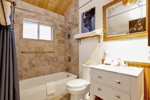 Ein Badezimmer mit Badewanne, Toilette und Waschtisch.
