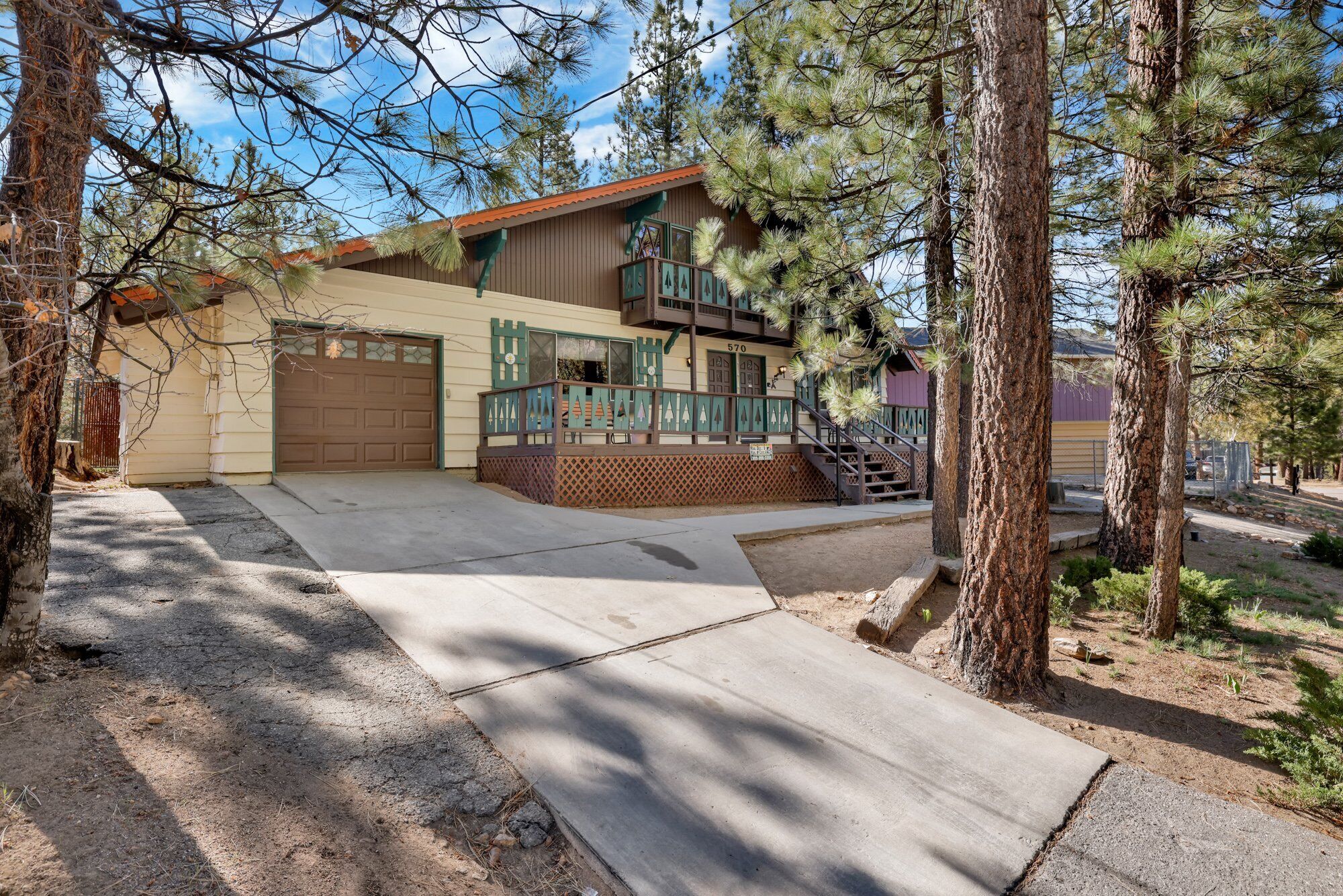 A two-story house with a garage, a balcony, and a staircase leading to the second floor.