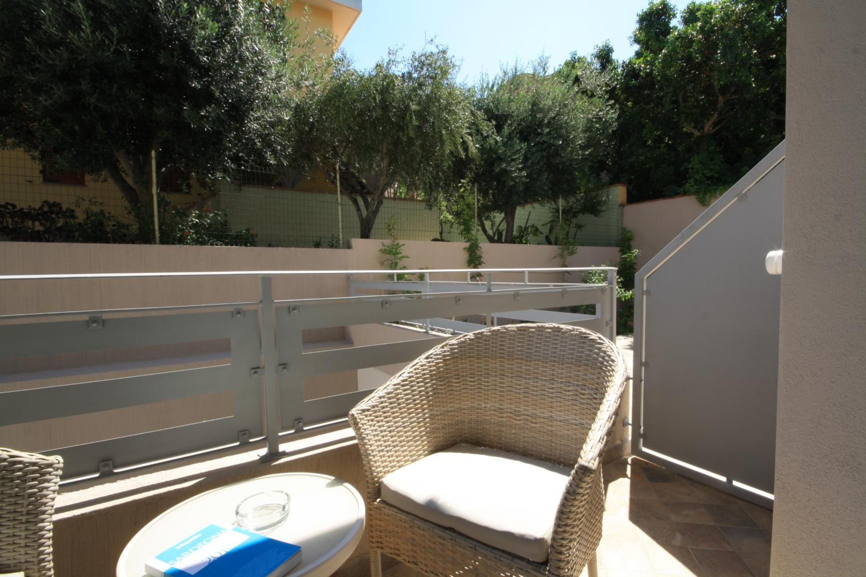 A balcony with wicker furniture, a small table, and a book.