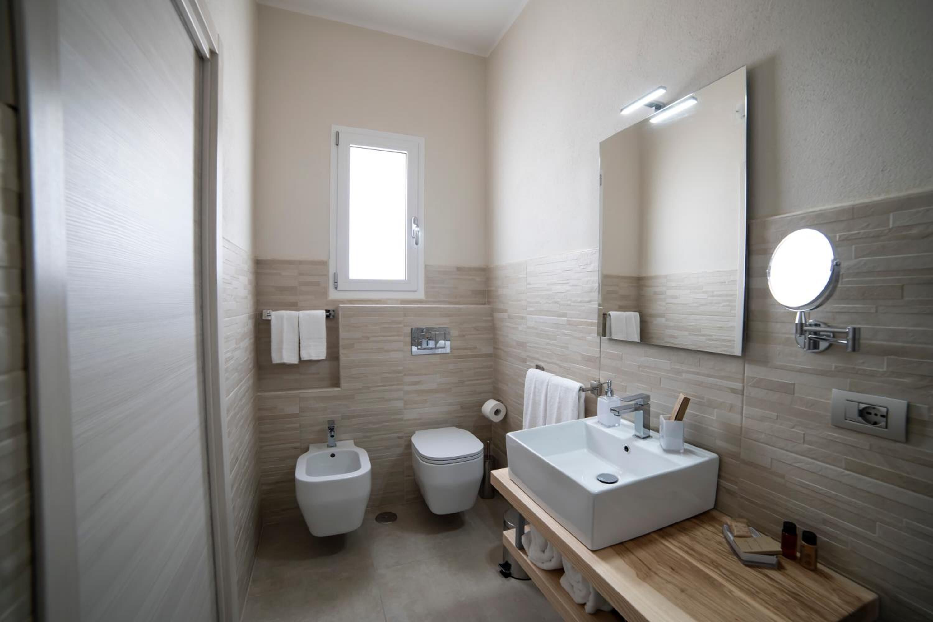 Un baño moderno con bidé, inodoro y lavamanos.