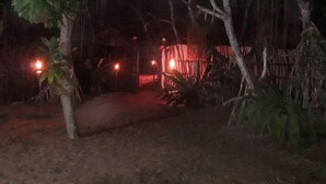 A nighttime scene with a pathway leading to a building, surrounded by trees and vegetation. - Akain Villa & Holiday Home (Hikkaduwa)