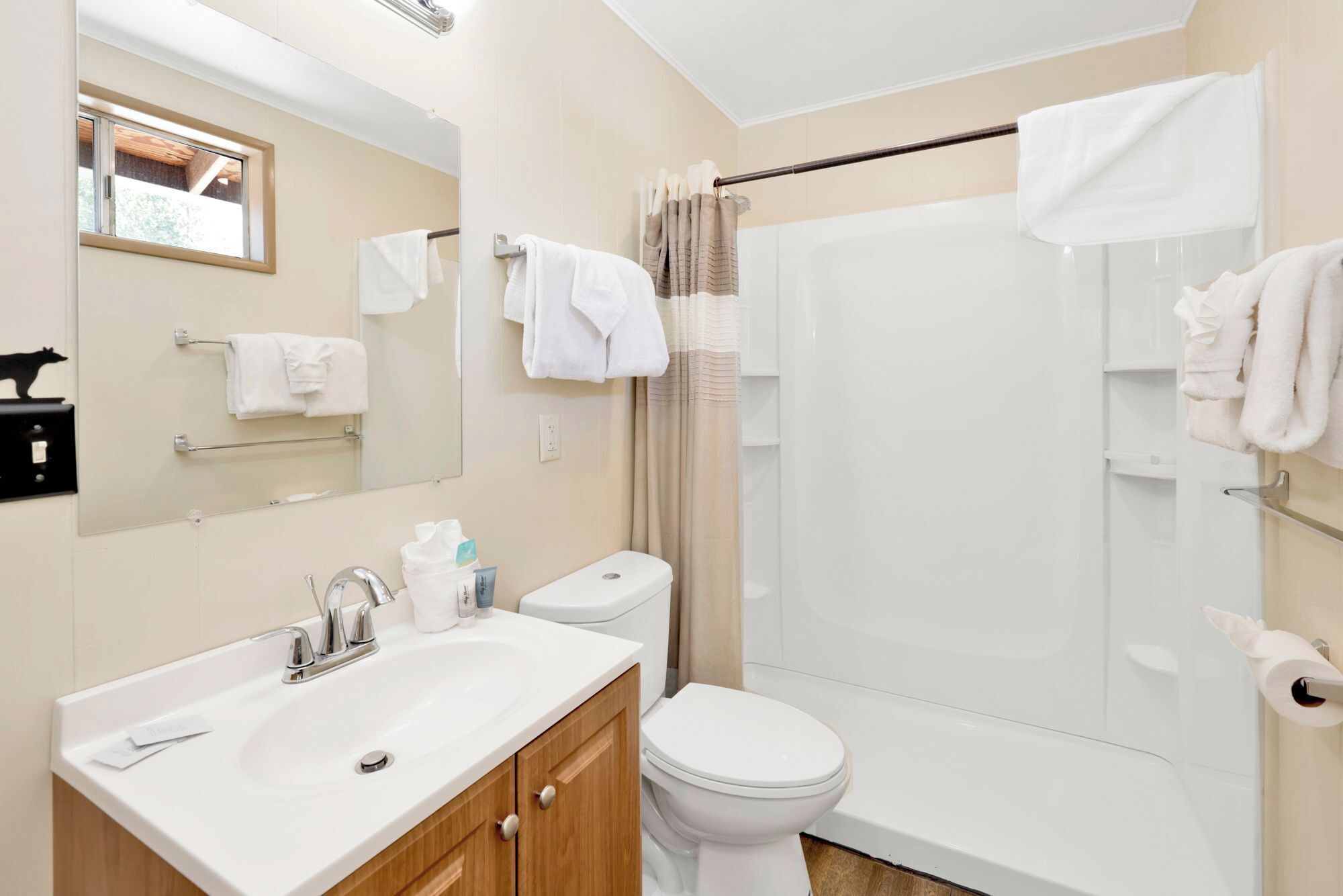 A modern bathroom with a sink, toilet, and walk-in shower.