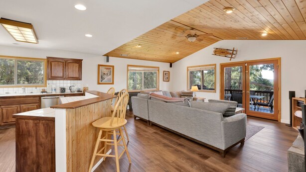 A spacious kitchen with wooden cabinets, a central island, and a dining area with a sofa and chairs. - I Love View #1475 (Big Bear City)