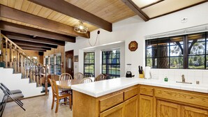 A kitchen with wooden cabinets, a white countertop, and a large window.