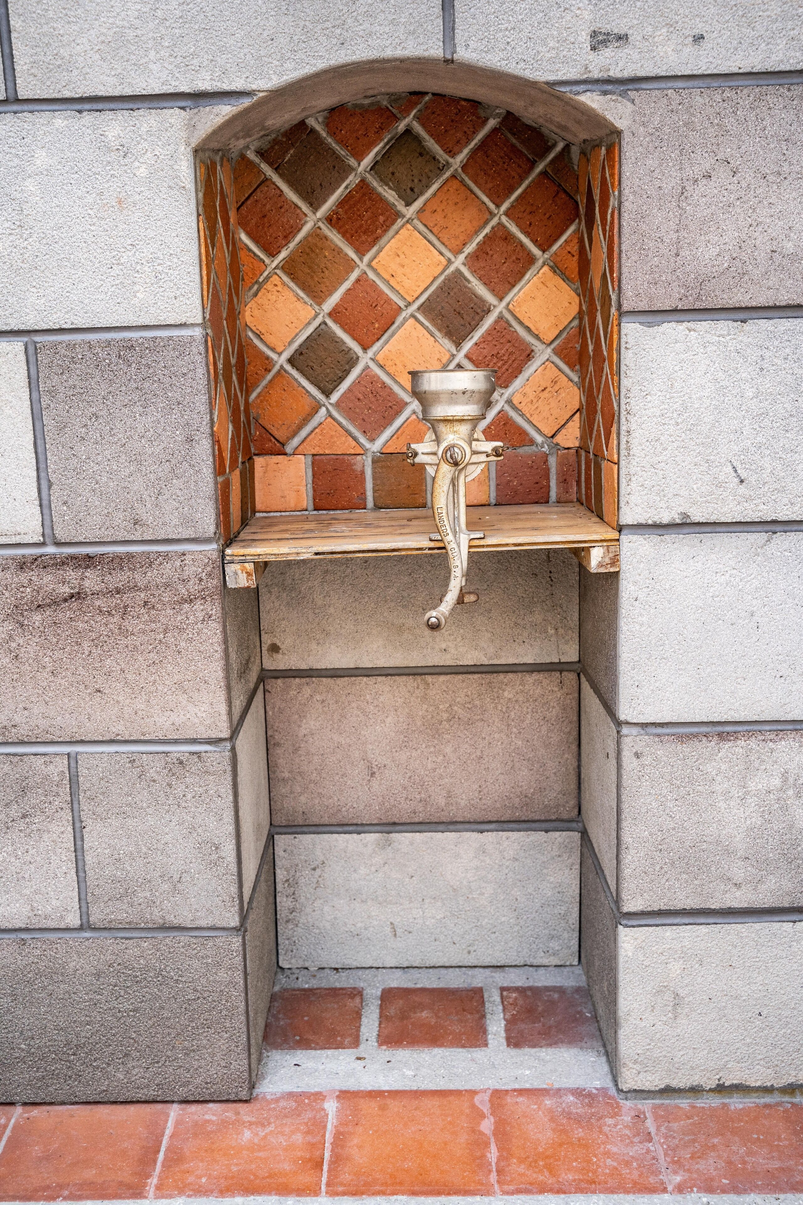 Un lavabo de piedra con salpicadero de azulejos en un rincón del edificio.