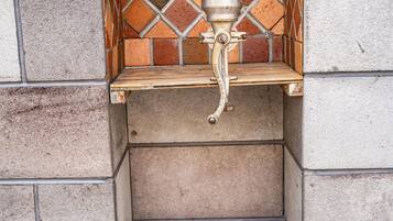 Un lavabo de piedra con salpicadero de azulejos en un rincón del edificio.
