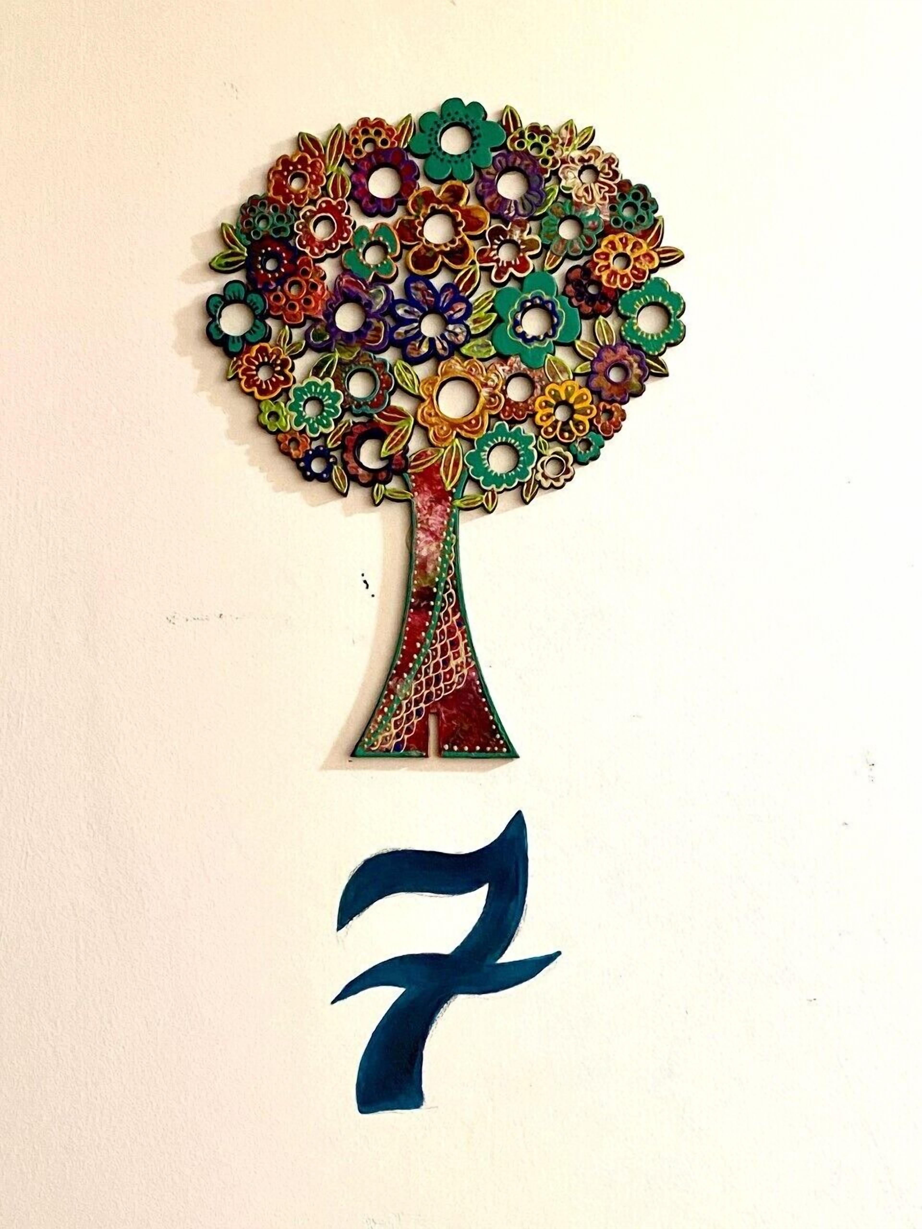 Un árbol decorativo con flores de colores y el número 7 debajo.