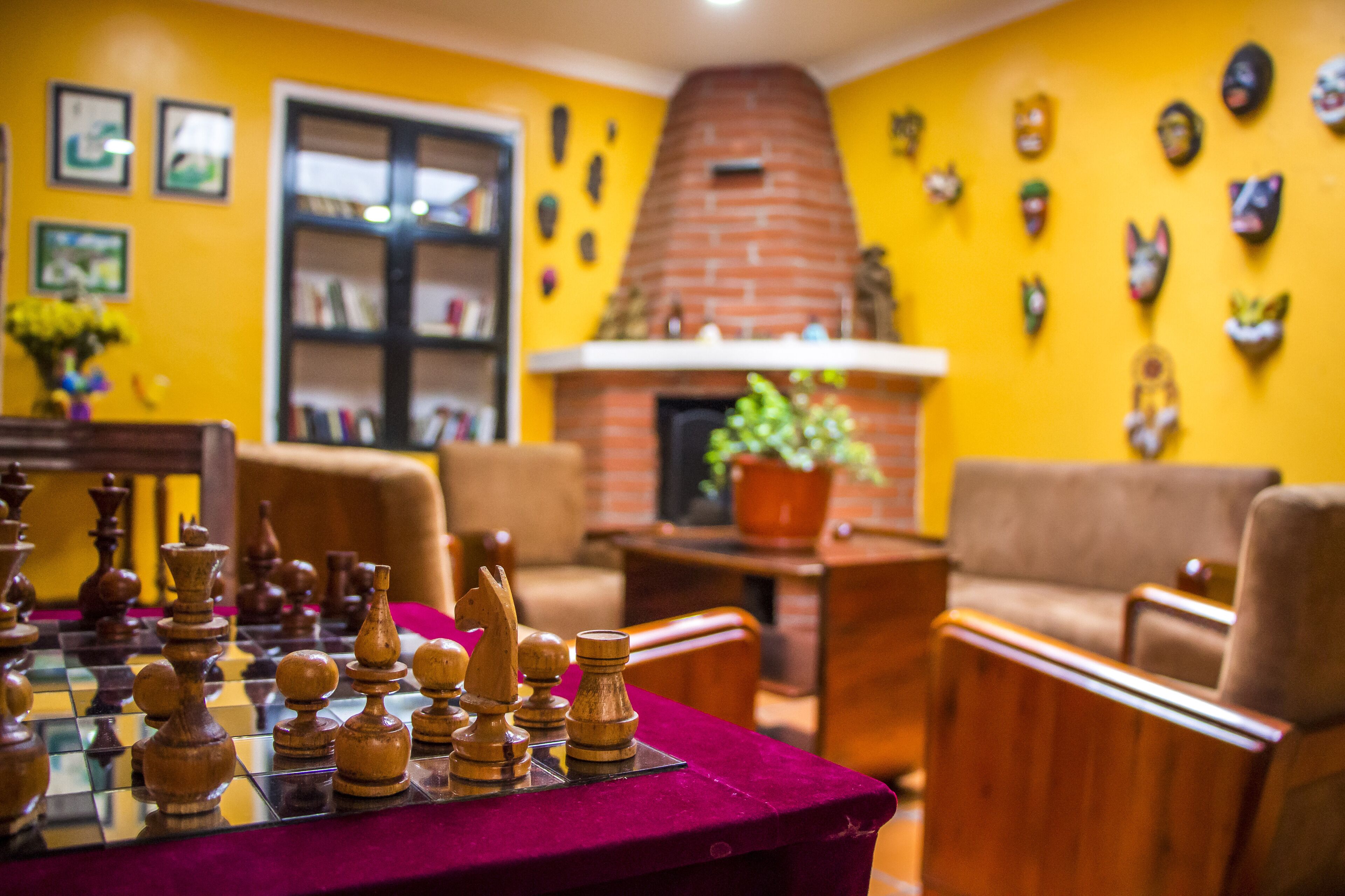 A room with a chessboard, a fireplace, and various wall decorations.