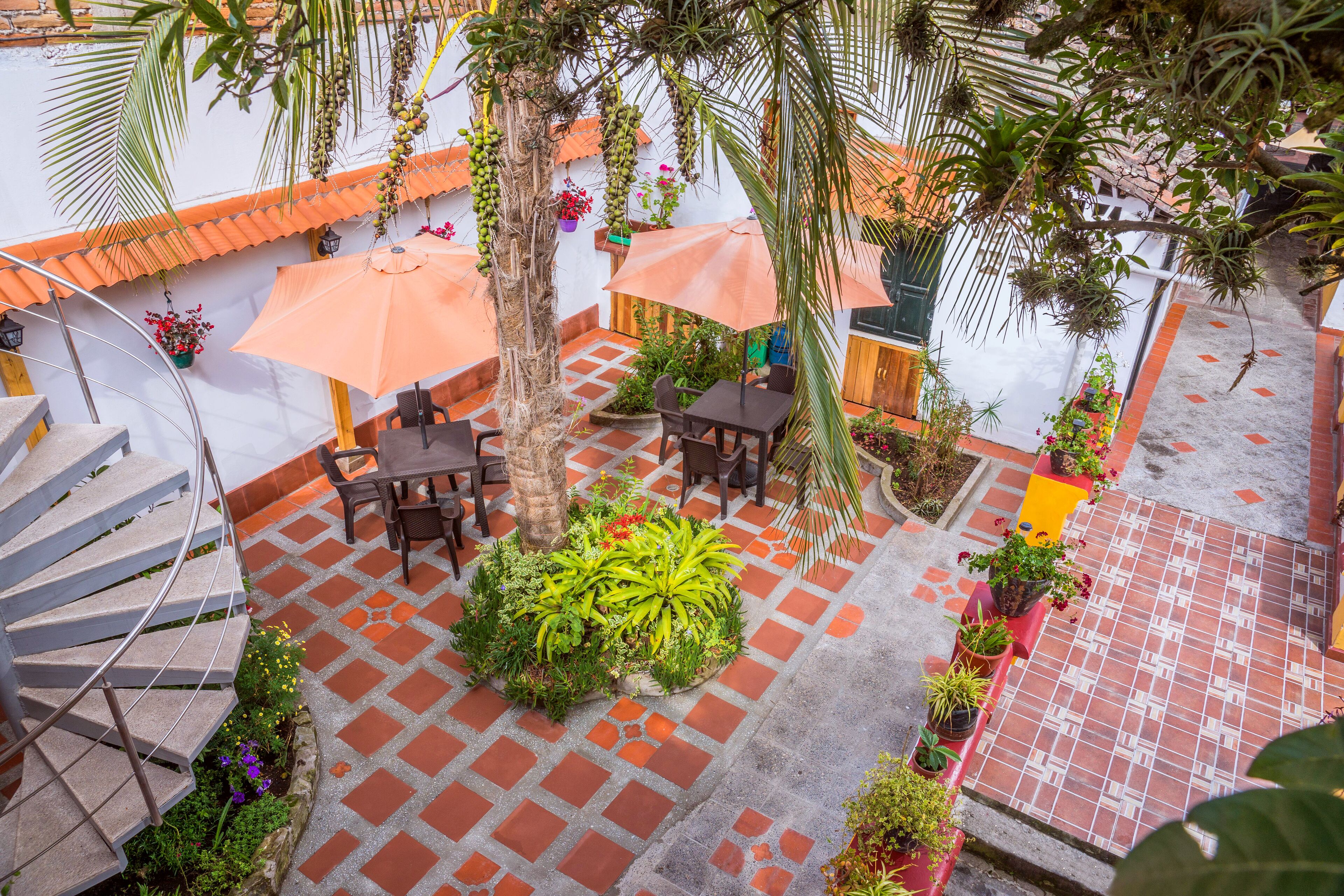 Un patio con mobiliario exterior, una escalera y macetas.