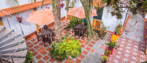 Un patio con mobiliario exterior, una escalera y macetas.