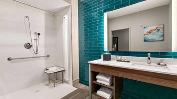 A modern bathroom with a shower, a sink with a mirror, and a towel rack.