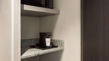 A coffee machine on a countertop with a cup underneath.