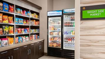 A snack aisle with various packaged foods and a freezer section labeled "Frozen Food" and "Cold Drink."