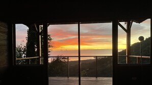 Una stanza con una grande finestra che si affaccia su un panorama al tramonto.