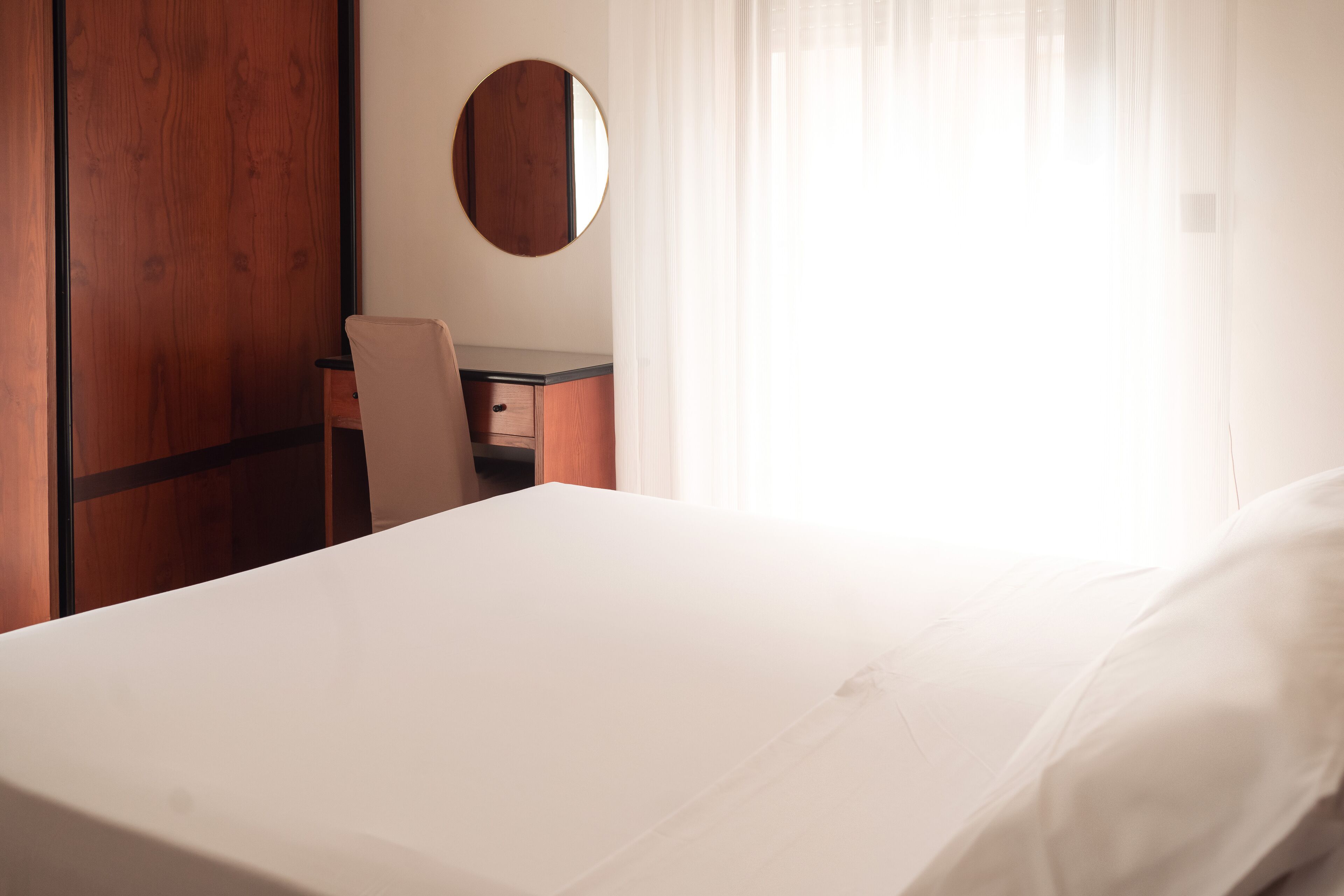 Ein Hotelzimmer mit einem Bett, einem Schreibtisch und einem Sessel.