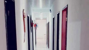 A long, narrow hallway with tiled floors and doors on both sides. - Pousada Tia Cota (Barreirinhas)