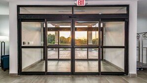 A hotel entrance with a glass door and an EXIT sign above. - Comfort Suites DeSoto Dallas South (DeSoto)