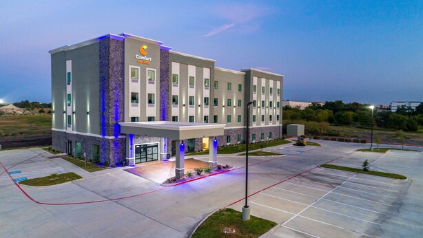 A modern Comfort Suites hotel with a covered entrance, multiple floors, and a parking lot. - Comfort Suites DeSoto Dallas South (DeSoto)
