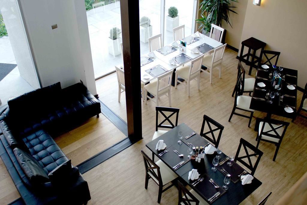 Un comedor con mesas y sillas, un sofá y vistas al exterior.